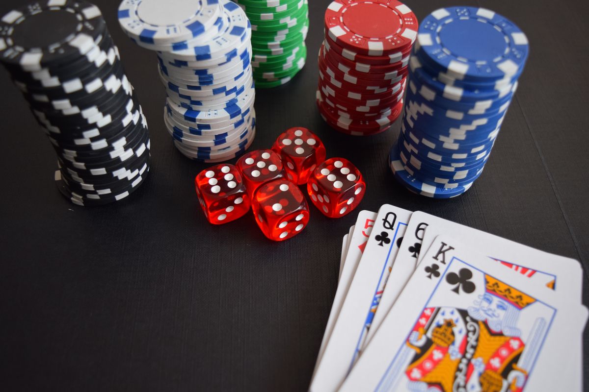 Chip, dadu, dan kartu permainan di atas meja